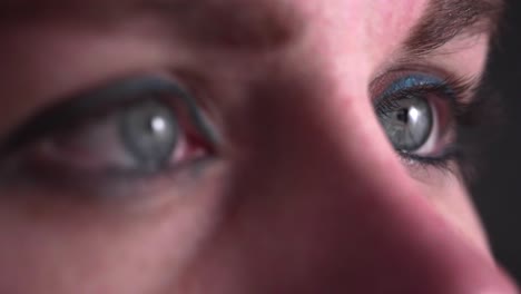 reflection of screen on person's blue green eye in dark room 20