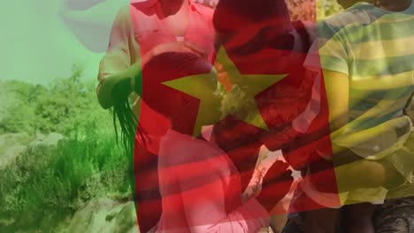 Animation-of-flag-of-cameroon-waving-over-happy-african-american-soldier-father-and-family-embracing