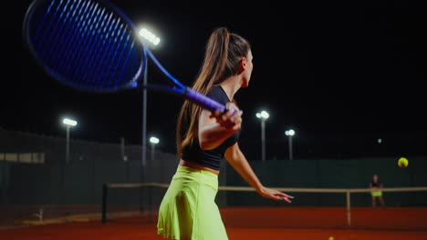 woman playing tennis at night