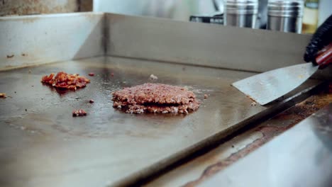 Imágenes-Cinematográficas-De-Cocina-De-Comida-De-4k-De-Un-Chef-Preparando-Y-Haciendo-Una-Deliciosa-Hamburguesa-Casera-En-La-Cocina-De-Un-Restaurante-En-Cámara-Lenta-Volteando-Las-Hamburguesas