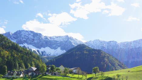 a drone shot of houses on the hill and reveal a snow mountain at the back