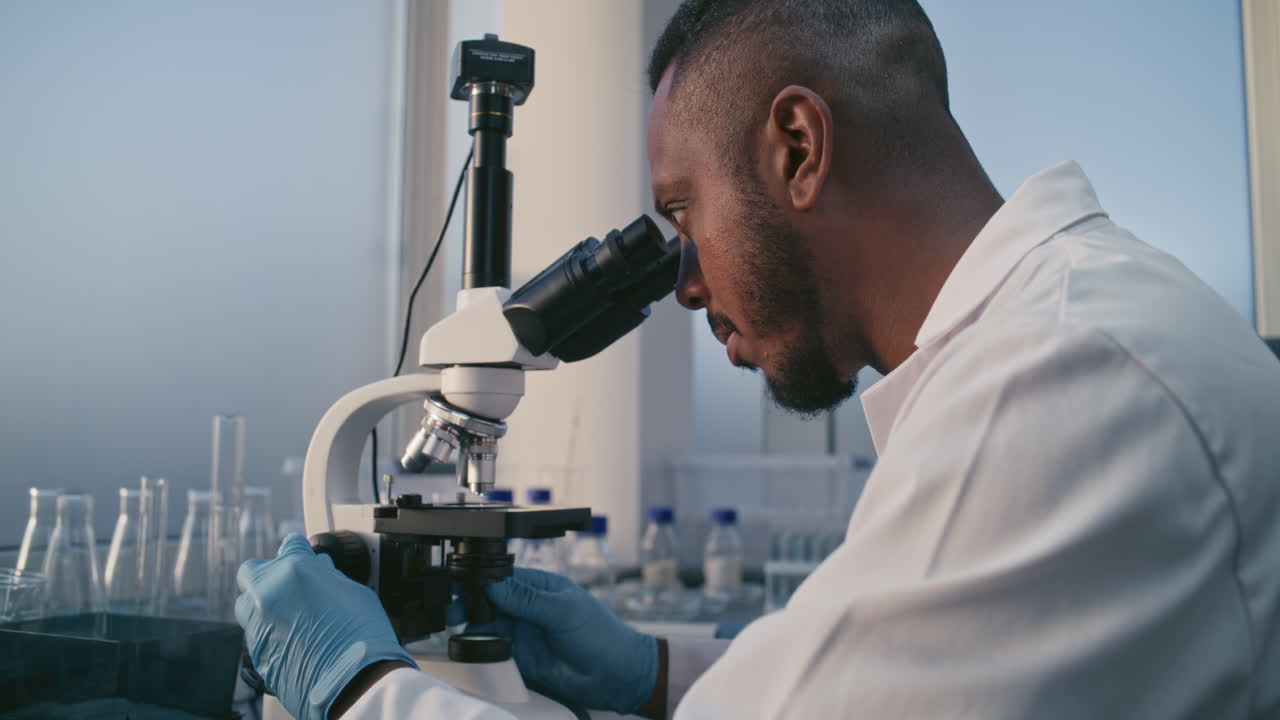 científico usando el microscopio en un entorno de laboratorio