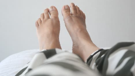 los pies descalzos de una mujer en una cama