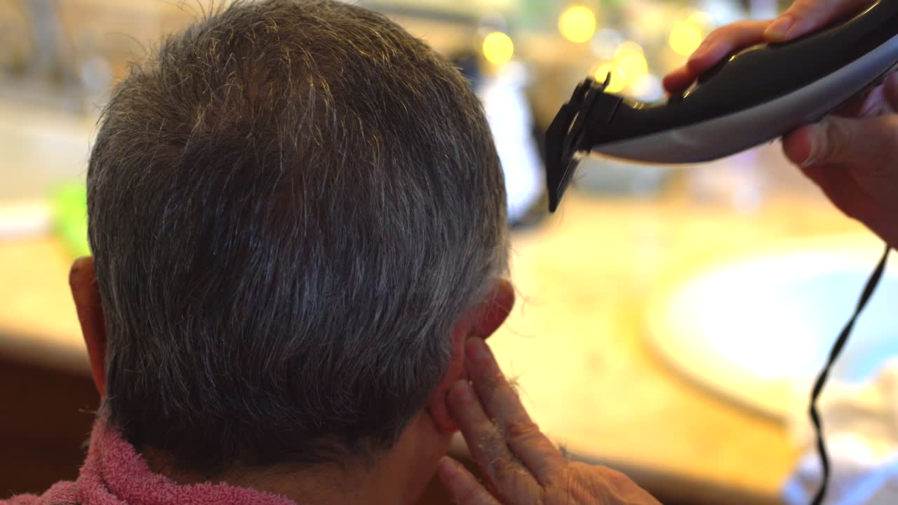Close up of Grandfather getting hair cut at home