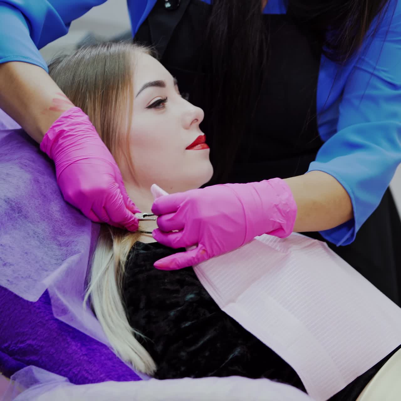 Young woman in a beauty salon. Beautician prepares female patient before the tattoo procedure. Cosmetology concept.