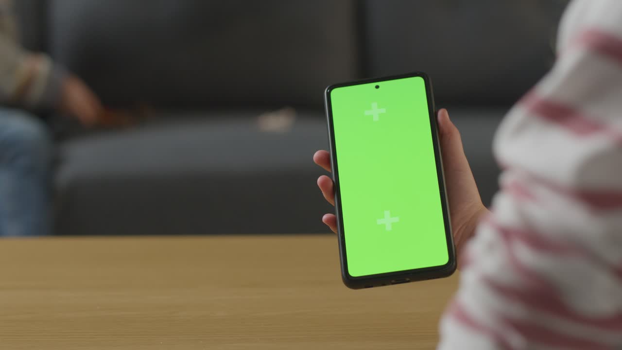 소년 이 장난감 공 ⁇  과 함께 놀고 있는 장면 과 소녀 가 화면 휴대전화 를 사용 하고 있는 장면