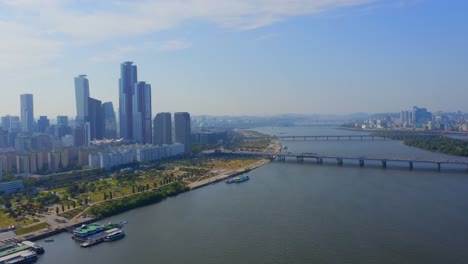 disparo de un dron que avanza sobre el río han hacia el puente mapo y un distrito comercial con rascacielos en la ciudad de seúl durante el día-1