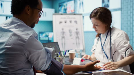 female medic measuring blood pressure and pulse for a patient