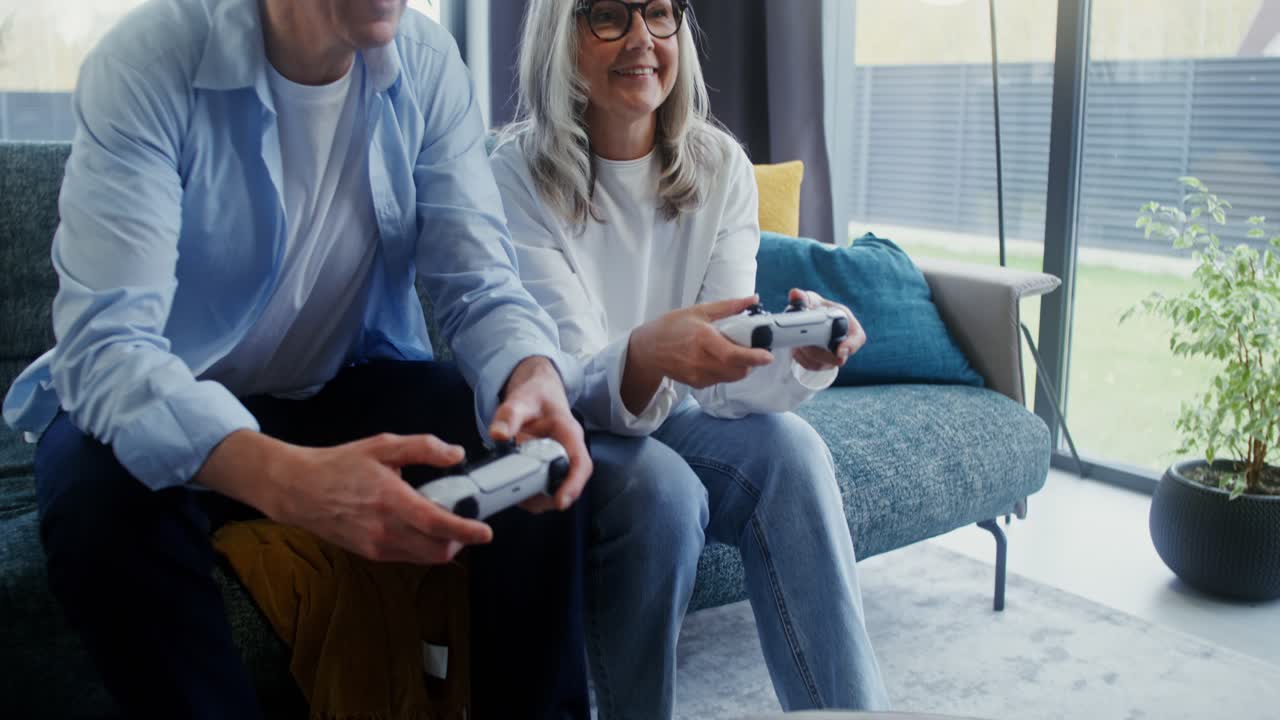 una pareja de ancianos jugando videojuegos en casa.