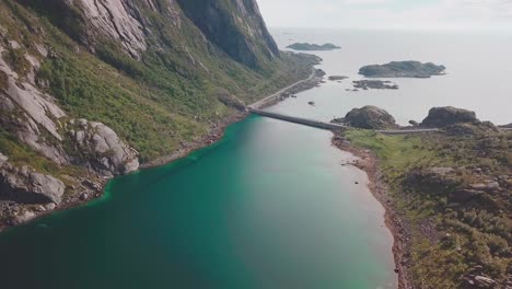 Crane-down-drone-shot-over-the-sea-with-rocky-cliffs-on-the-side