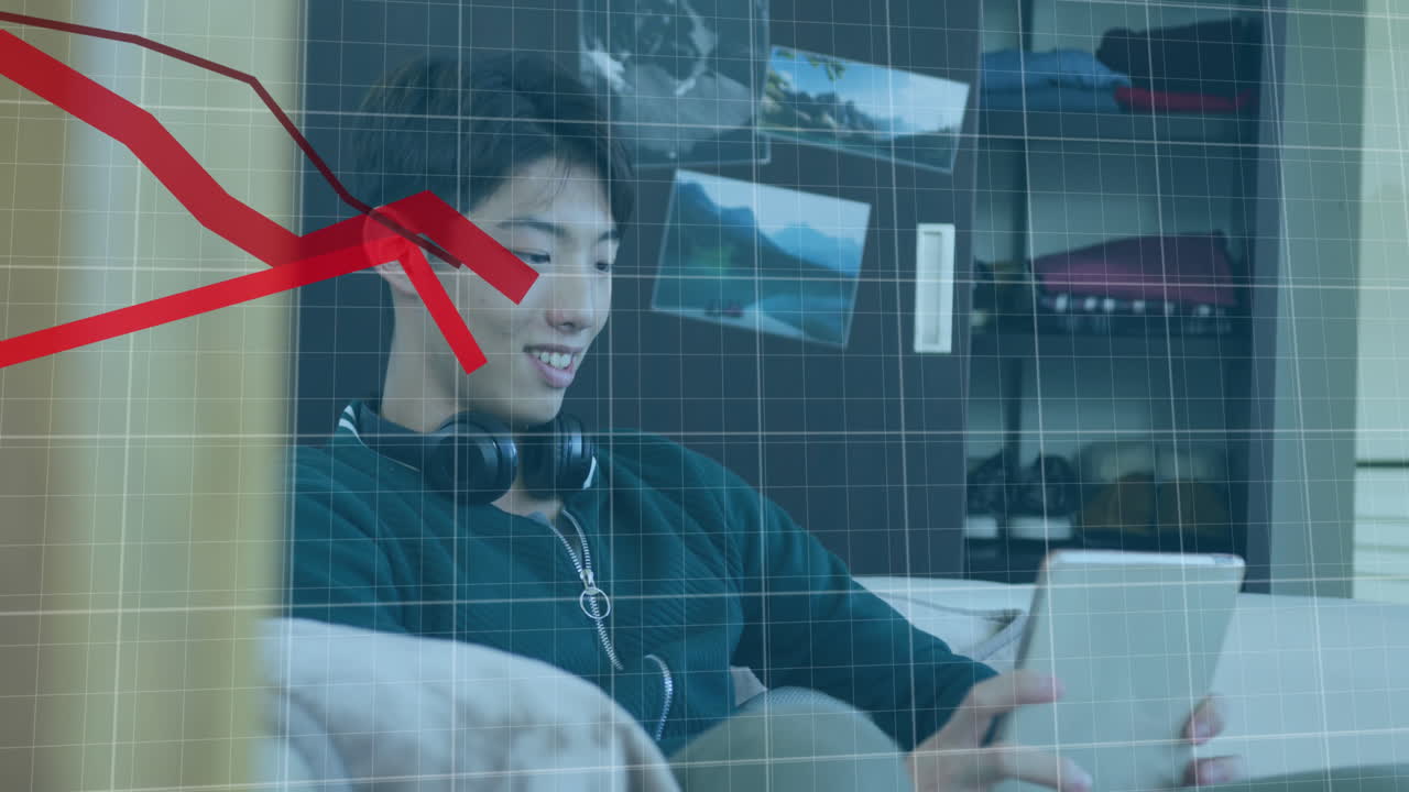 디지털 태블릿에서 게임을 하는 아시아 소년 위에 떨어지는 여러 그래프의 애니메이션