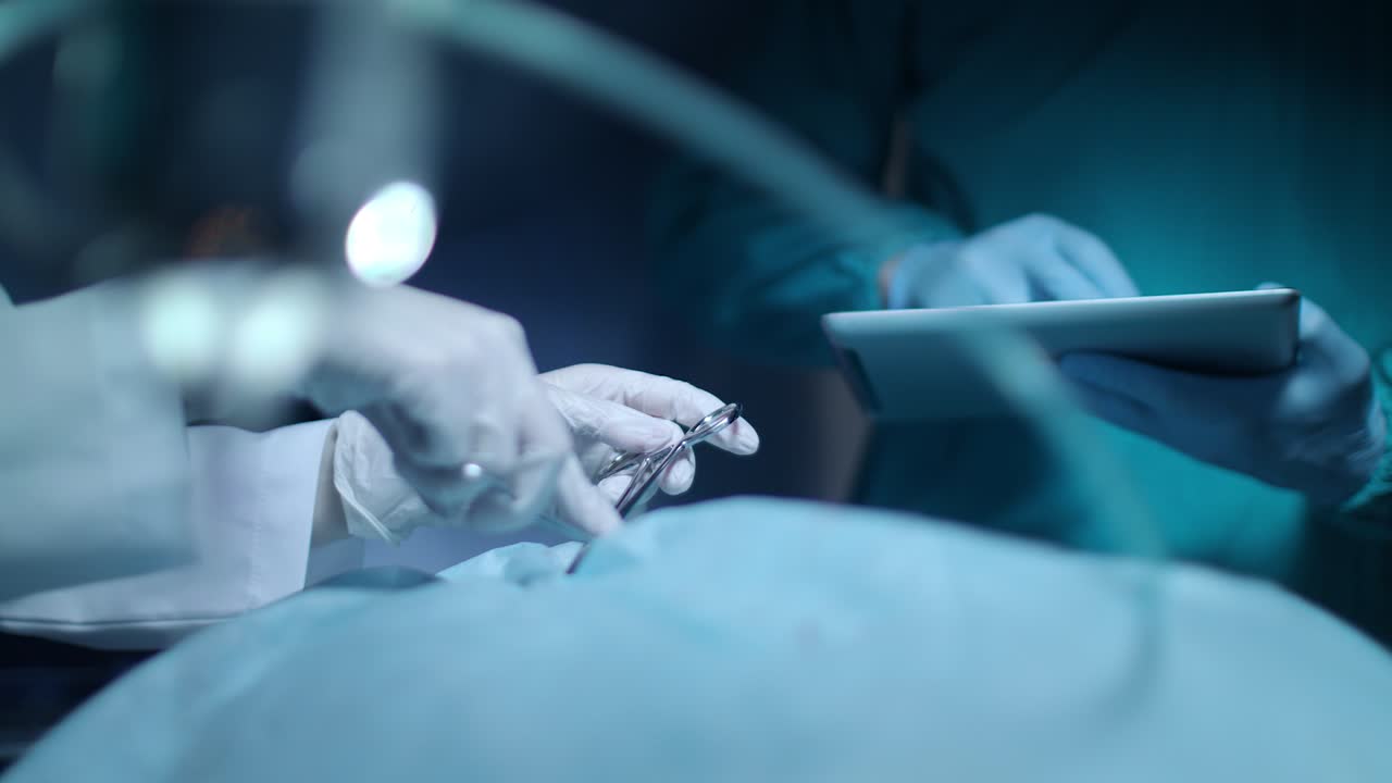 хирург использует таблетку. медицинская таблетка в хирургической руке. хирург операционная команда