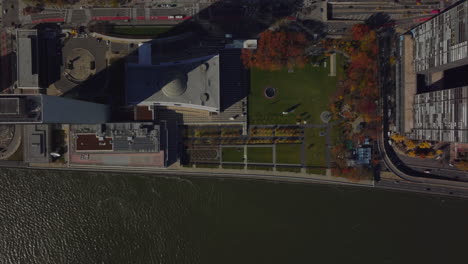 Aerial-birds-eye-overhead-top-down-view-of-UN-headquarters-buildings-on-East-River-waterfront.-Autumn-colour-trees-and-busy-road.-Manhattan,-New-York-City,-USA