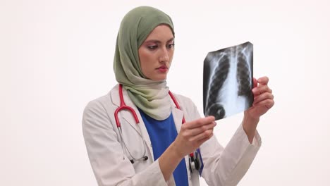 female doctor in hijab examining x-ray