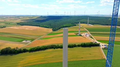Fliegen-In-Der-Nähe-Des-Windturbinenturms,-Der-Auf-Dem-Feld-Neben-Dem-Hebekran-In-Österreich-Installiert-Ist