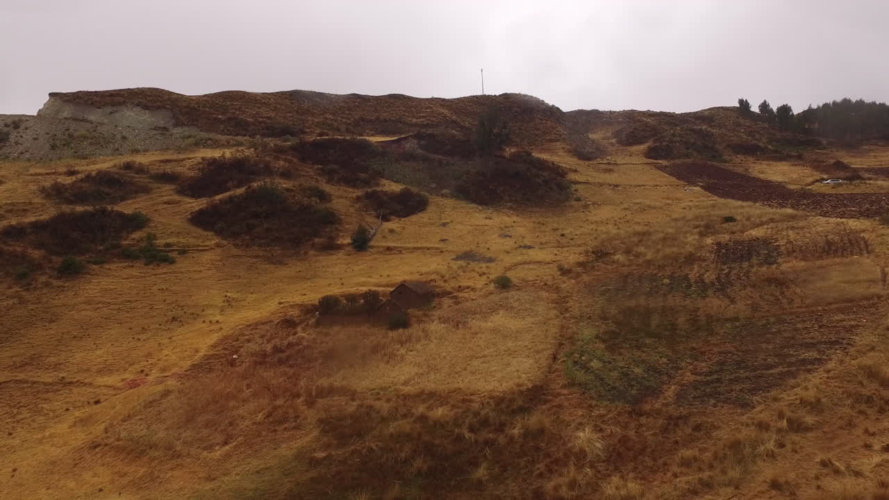 toma aérea de una pequeña casa en ruinas dentro de un valle montañoso en una jungla en perú