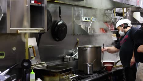 chef stirring pot in a professional kitchen