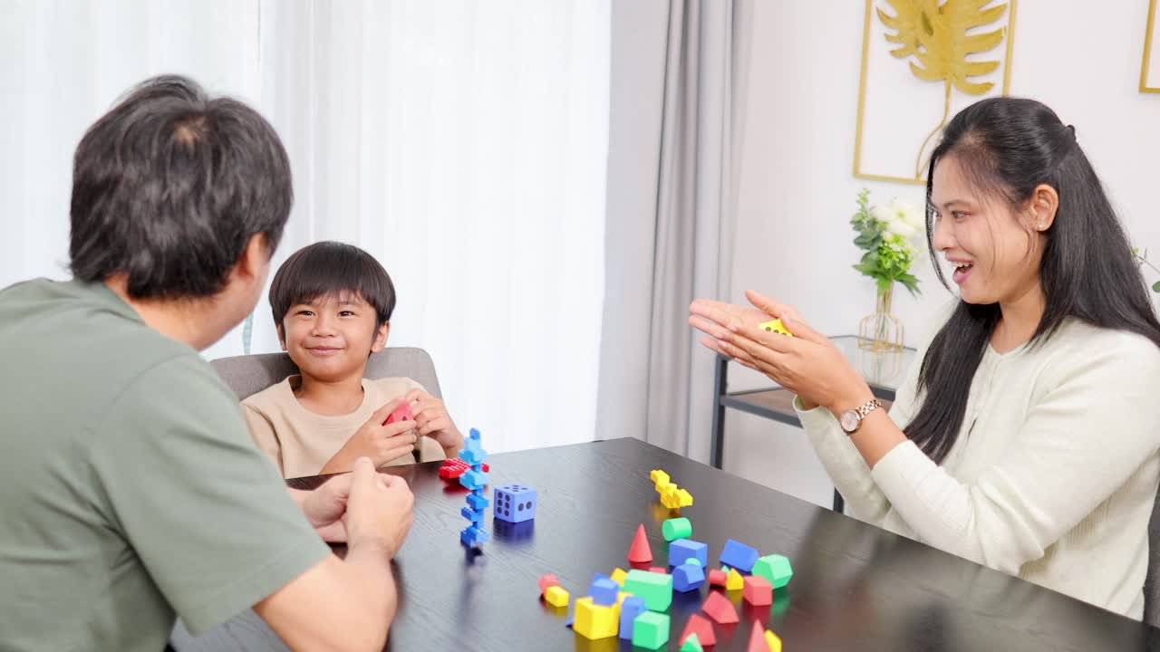 Family playing and learning together with colorful dice and shapes in a bright, cheerful home