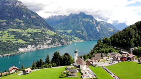 Aerial-flyover-over-the-village-of-Seelisberg-and-its-church-towards-Lake-Lucerne-in-Uri,-Switzerland