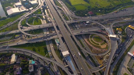 aerial view of highway road interchange with busy urban traffic speeding on road