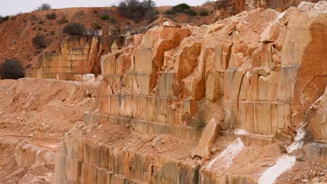 limestone quarry mine with cut layered walls from removed blocks , pan right shot