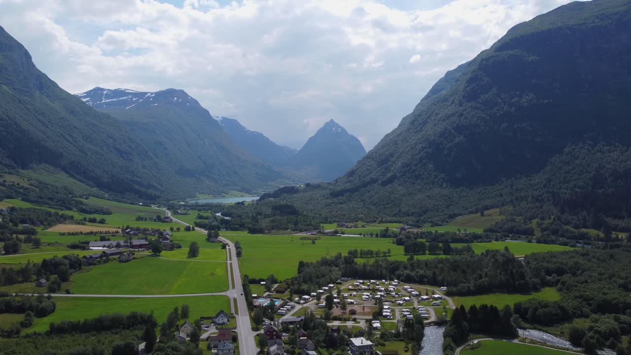 aldea y valle en byrkjelo con montaña puntiaguda eggjenibba en el fondo - día de verano inverso noruega aérea