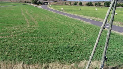 Drone-shot-going-done-road-between-farm-lands