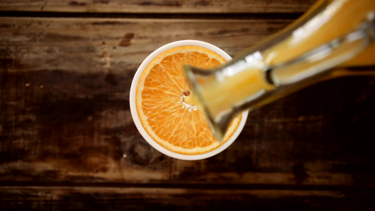 Topbillede af appelsinjuice, der hældes i en keramikkop
