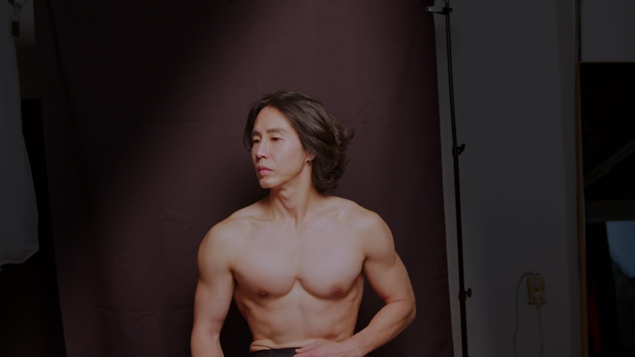 아시아 남자 남성 모델은 잘 훈련되고 매력적인 토플리스 근육 섹시한 잘 생긴 몸으로 포즈를 수행합니다