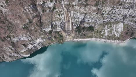 Aerial-of-Walensee's-cliffs-and-crystal-turquoise-waters-near-Quinten,-Switzerland