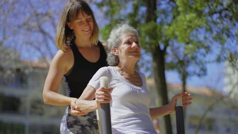 una mujer mayor sonriente entrenando con un entrenador personal.