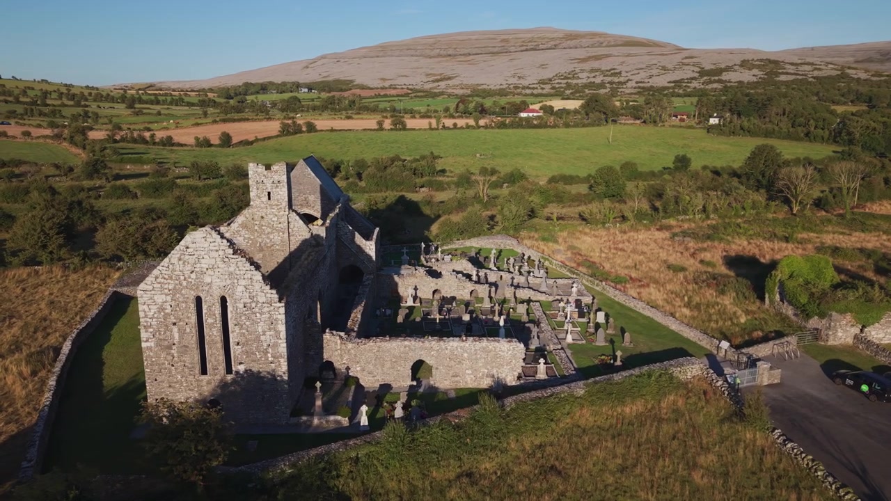 Ripresa aerea cinematografica delle rovine e del cimitero storici dell'Abbazia di Corcomroe nella regione del Burren in Irlanda durante l'ora d'oro. Ideale per documentari di viaggio e progetti sul patrimonio culturale