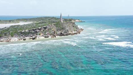 shallow blue sea with waves splashing on rocky island in summer