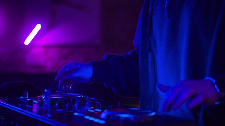 hombre con gorra negra pinchando en la discoteca.