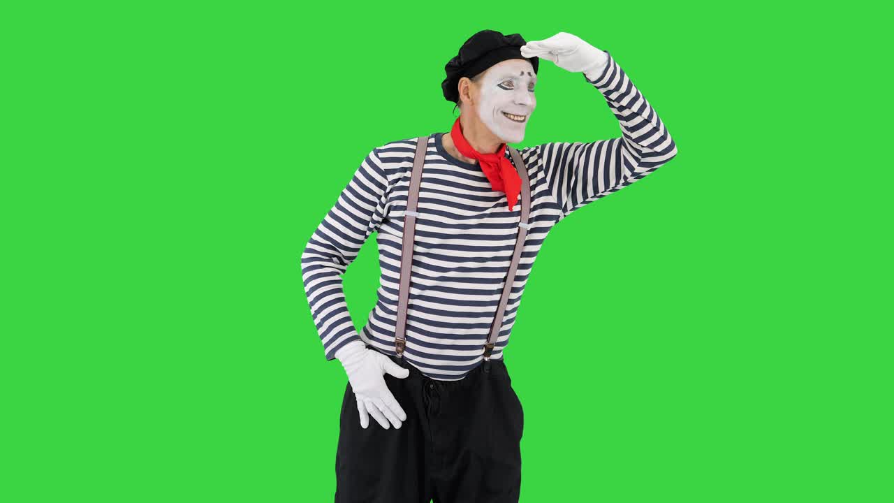 hombre vestido como mimo mirando lejos en una pantalla verde, llave de croma