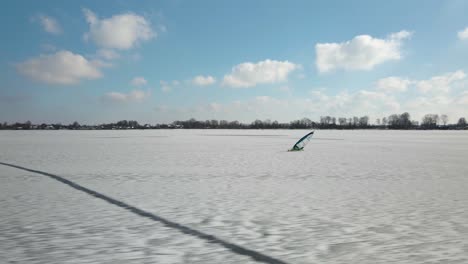 Kamerafahrt-Eines-Eisseglers,-Der-Mit-Einem-Segelboot-über-Eine-Weiße,-Schneebedeckte-Eislandschaft-Segelt---Zugefrorener-See-Bei-Sonnenlicht-Im-Winter