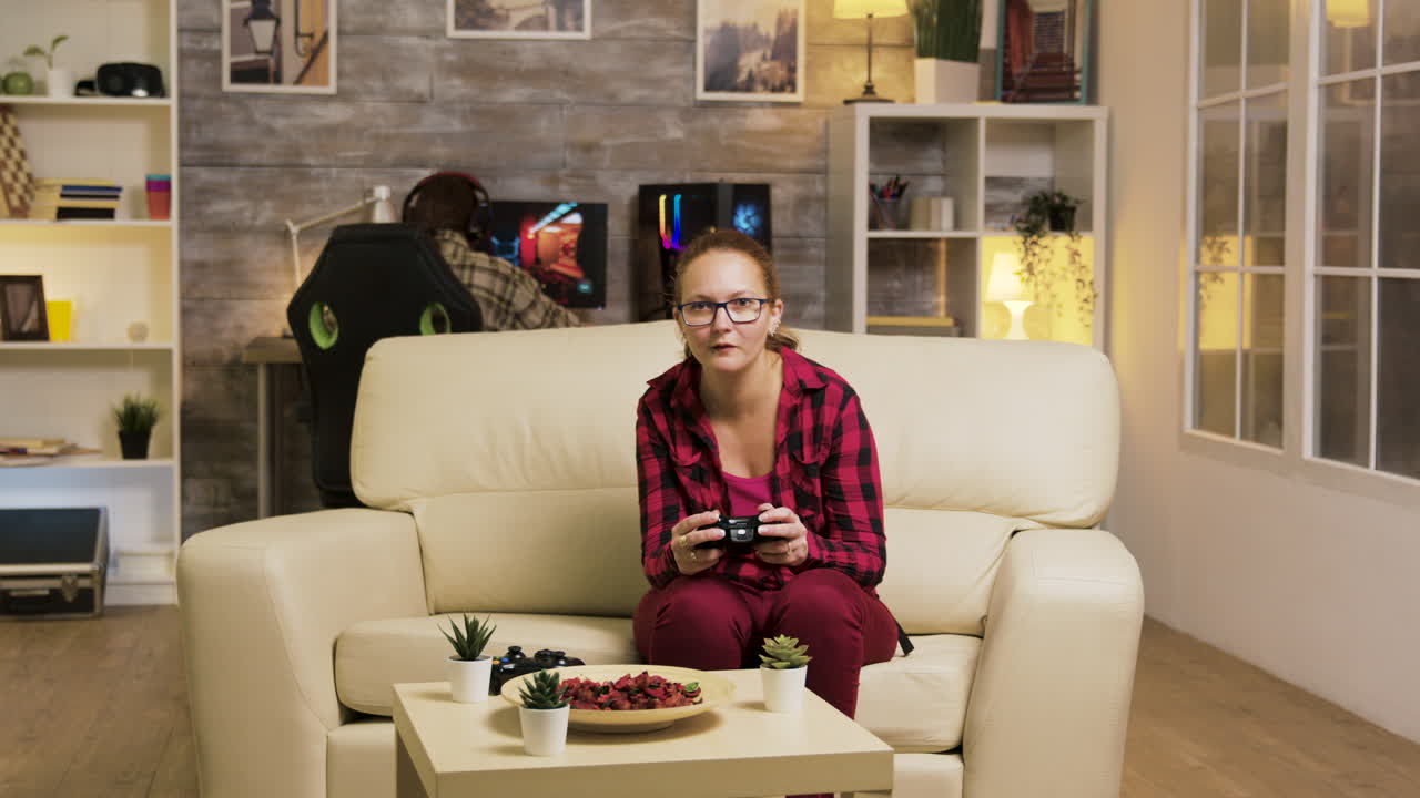 mujer jugando videojuegos en un sofá