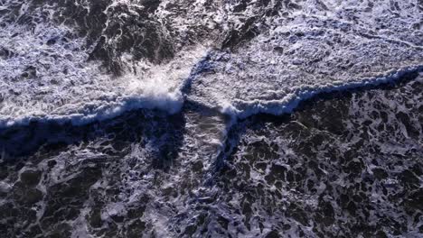 drone bird's eye push in over incoming waves at mavericks beach, california