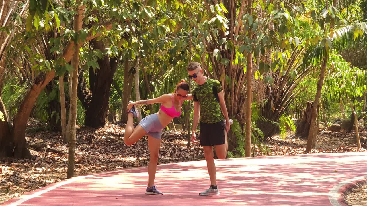 una pareja estirándose en el parque.