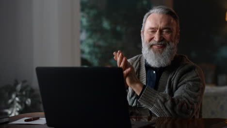 happy gentleman having video call on laptop at home