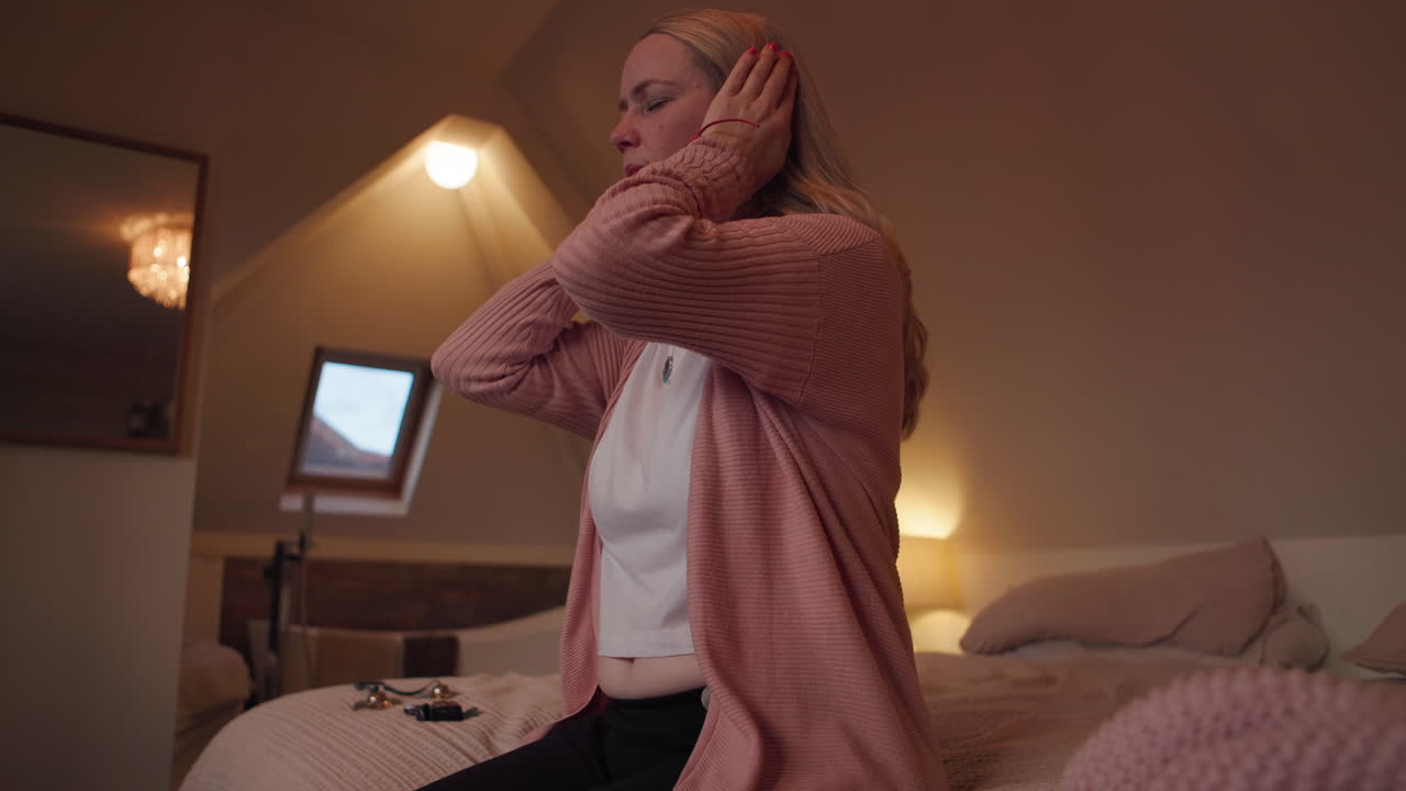 Woman covering her ears in a bedroom