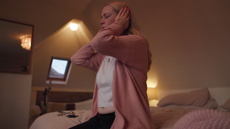 woman covering her ears in a bedroom