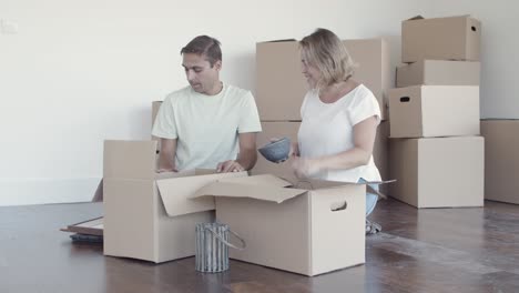 Happy couple packing things for moving