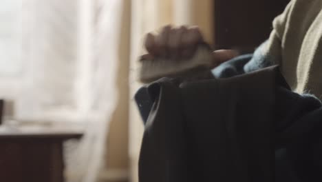 person cleaning clothes in an old house