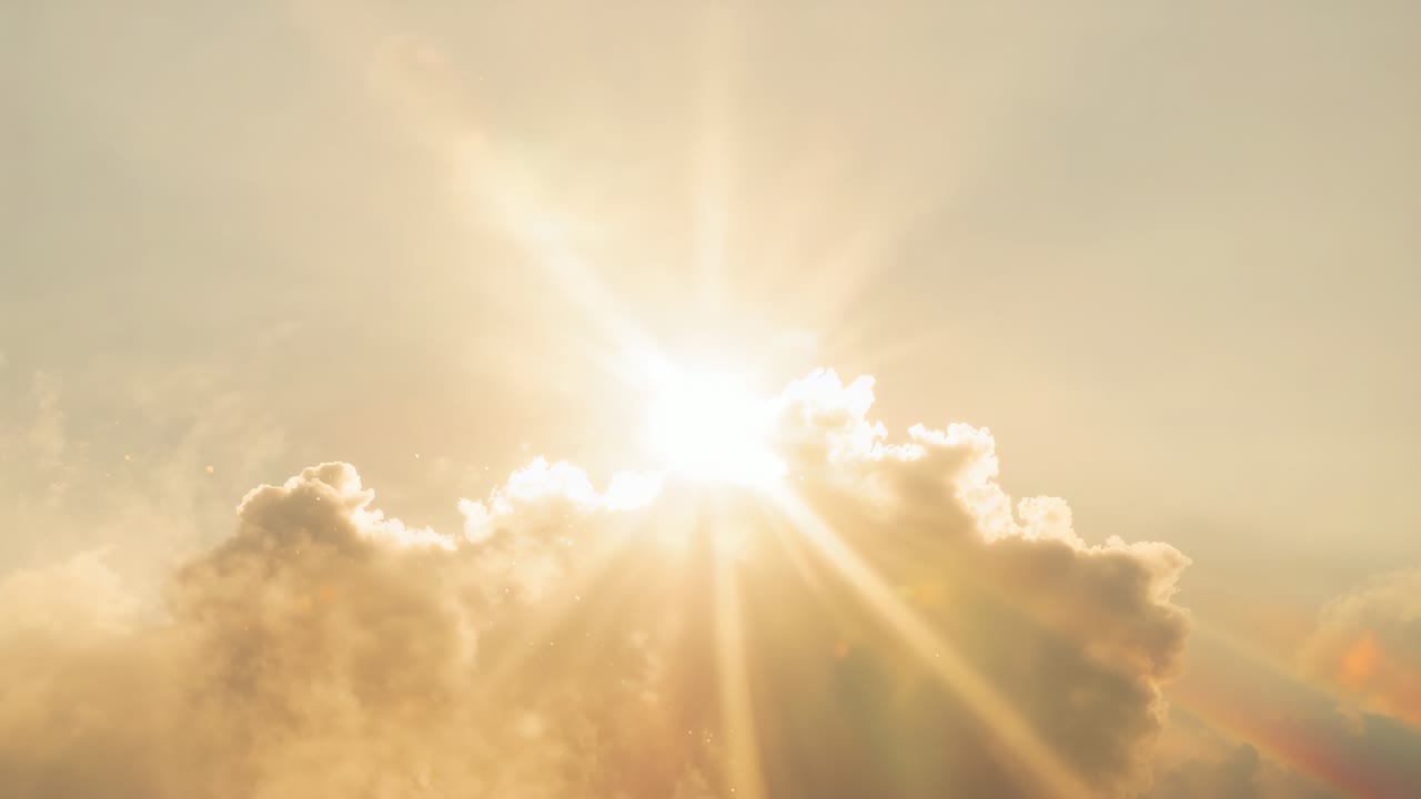 Emerging sun behind central cumulus crest revealing rays and lens flare, warming horizon sky