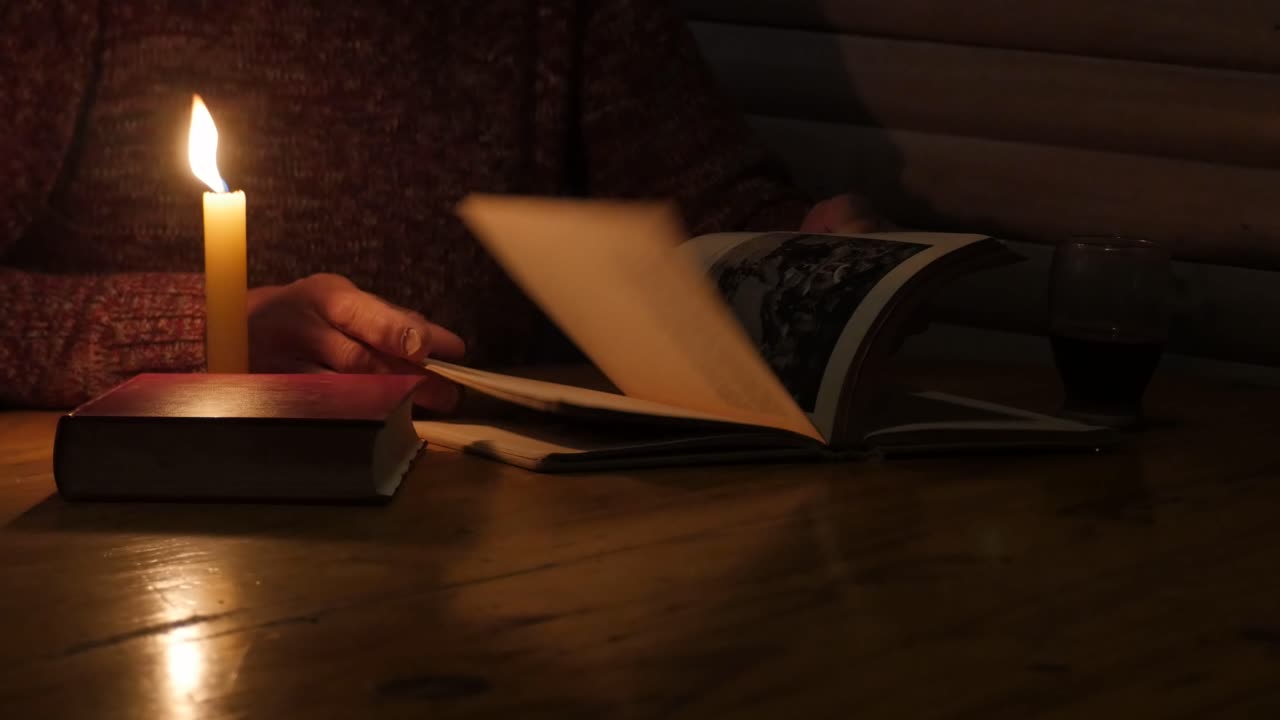 촛불 아래에서 맨 페이지를 통해 책을 닫습니다.