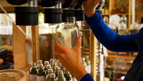 Close-up-of-woman-filling-grains-in-to-jar-from-vending-machine-4k