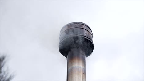chimney with smoke against sky