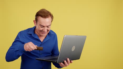 man using laptop with credit card for online shopping