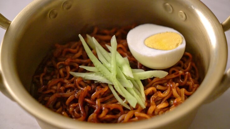 Noodles istantanei coreani con salsa di fagioli neri, guarniti con cetrioli e uovo sodo - Cucina coreana